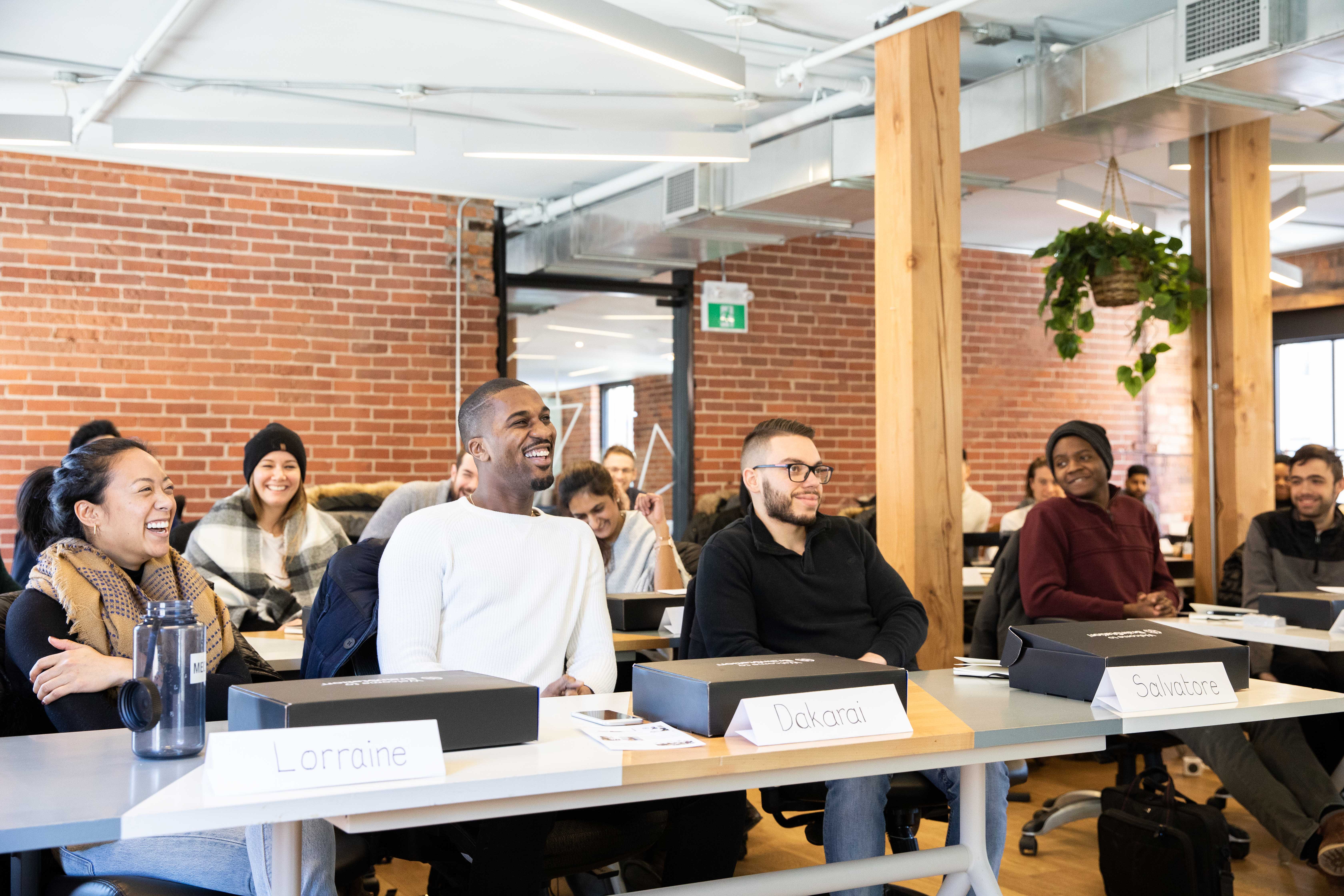 Learners working together around tables at BrainStation’s Toronto classroom