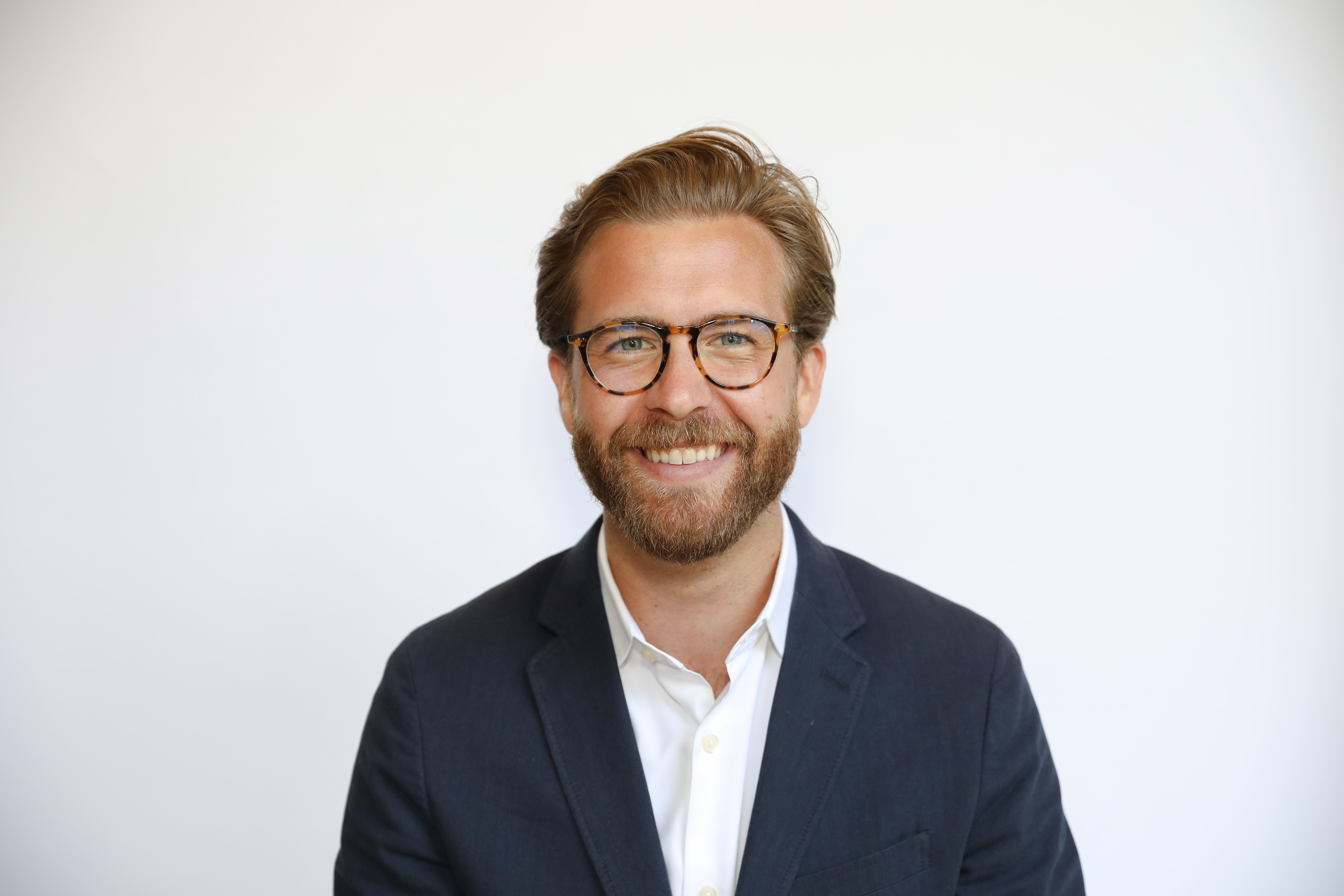 Jason Field in a navy jacket and white shirt in an official BrainStation press photograph