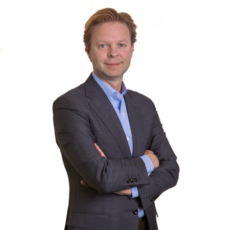 Jason Fox standing with his arms folded, wearing a grey jacket