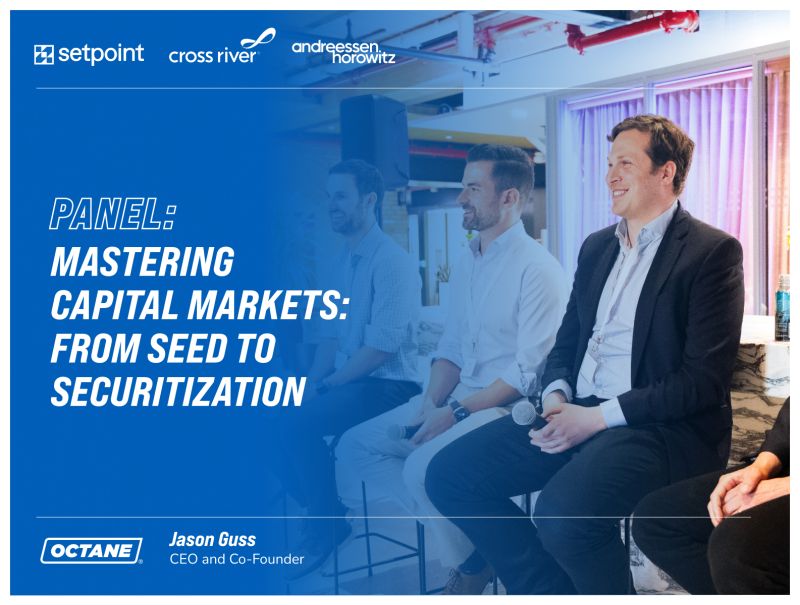 Jason Guss, seated at right with a microphone, taking part in a panel about capital markets