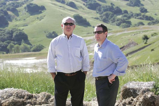 Michael Olson and Jason Keadjian standing on a grassy hillside at the Wilder development in 2007