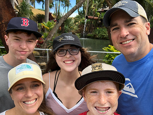 Jason Morris smiling with his family outdoors