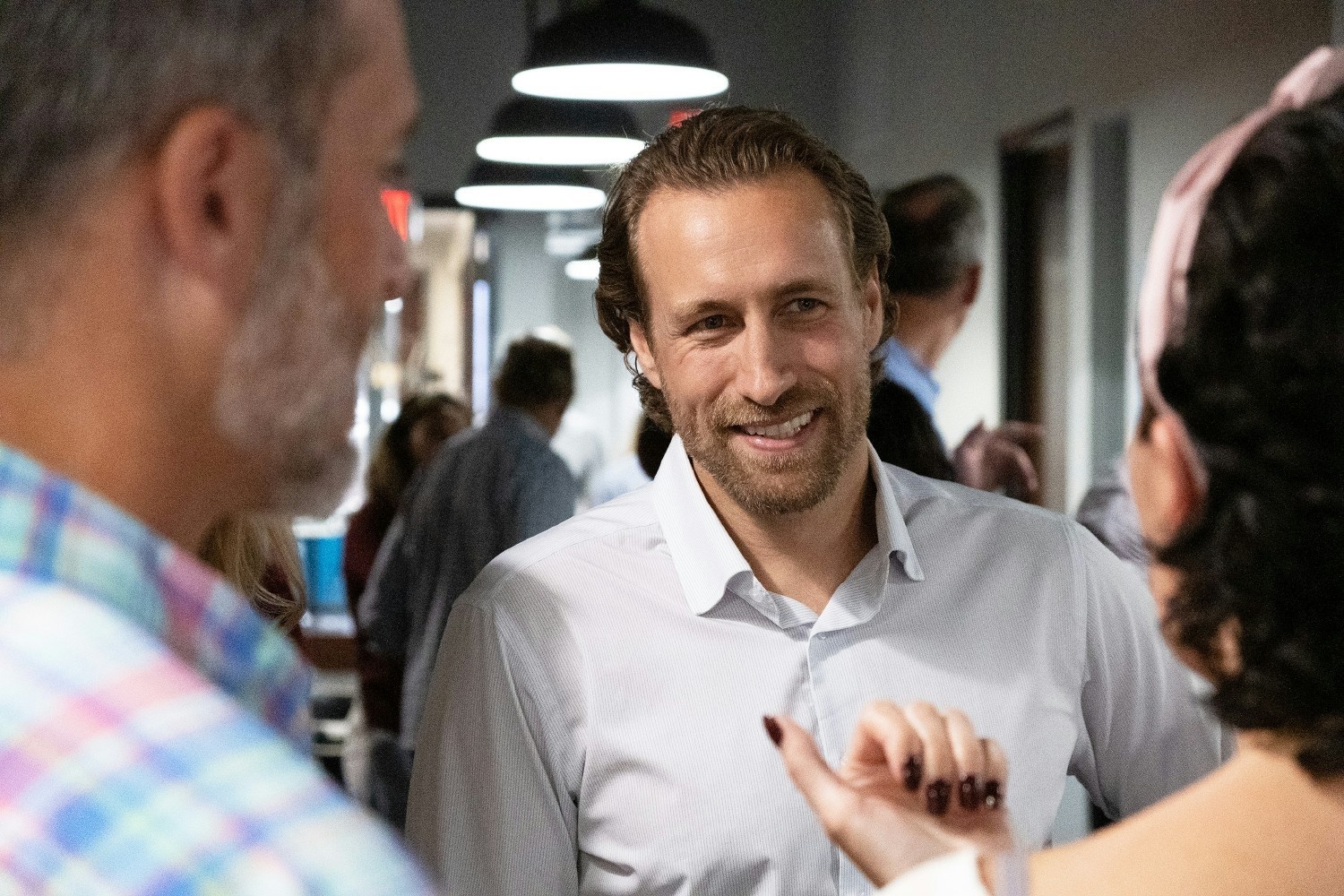 Jason Ray in conversation with guests at the Paperless Parts office opening party in 2021