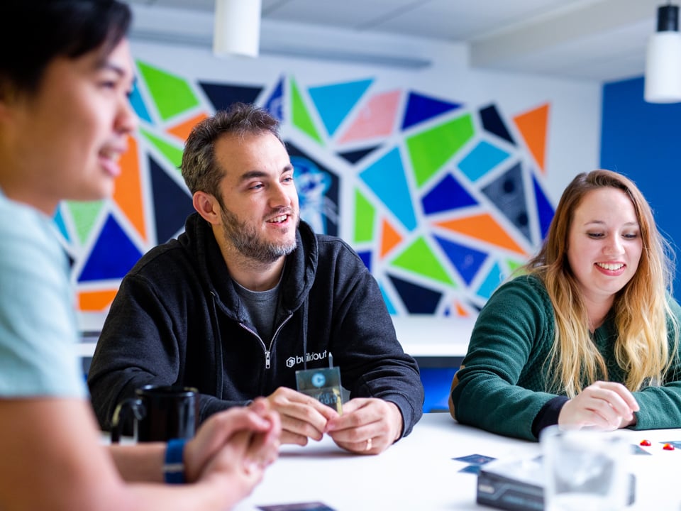 Jason Tillery, seated in the center, with colleagues at a table in Buildout’s colorful office