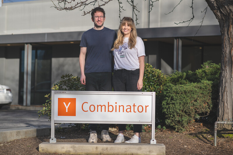 Jasper Story and Nicole Atack standing behind a Y Combinator sign