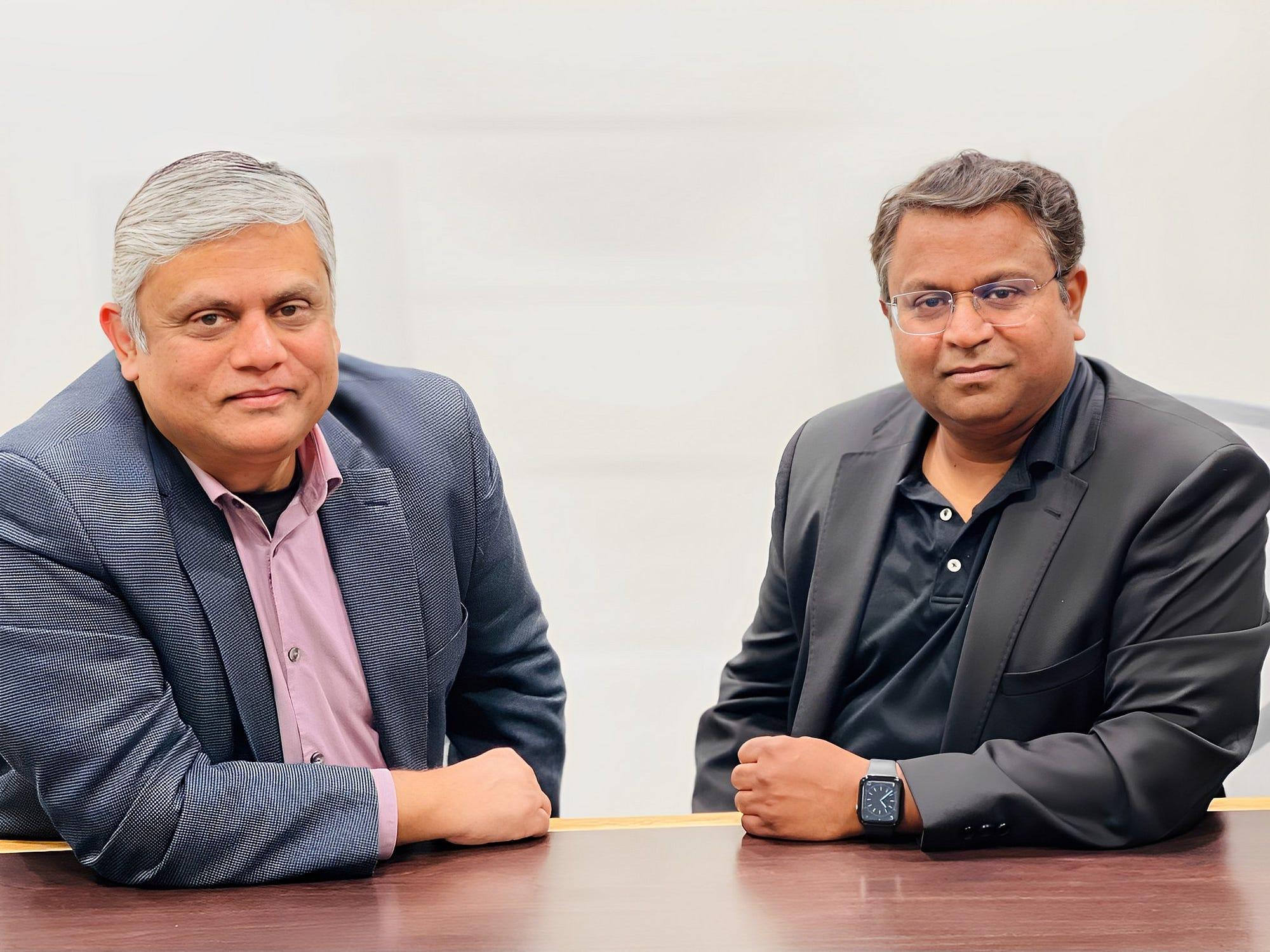 Javed Hasan, left, seated with a colleague at a table