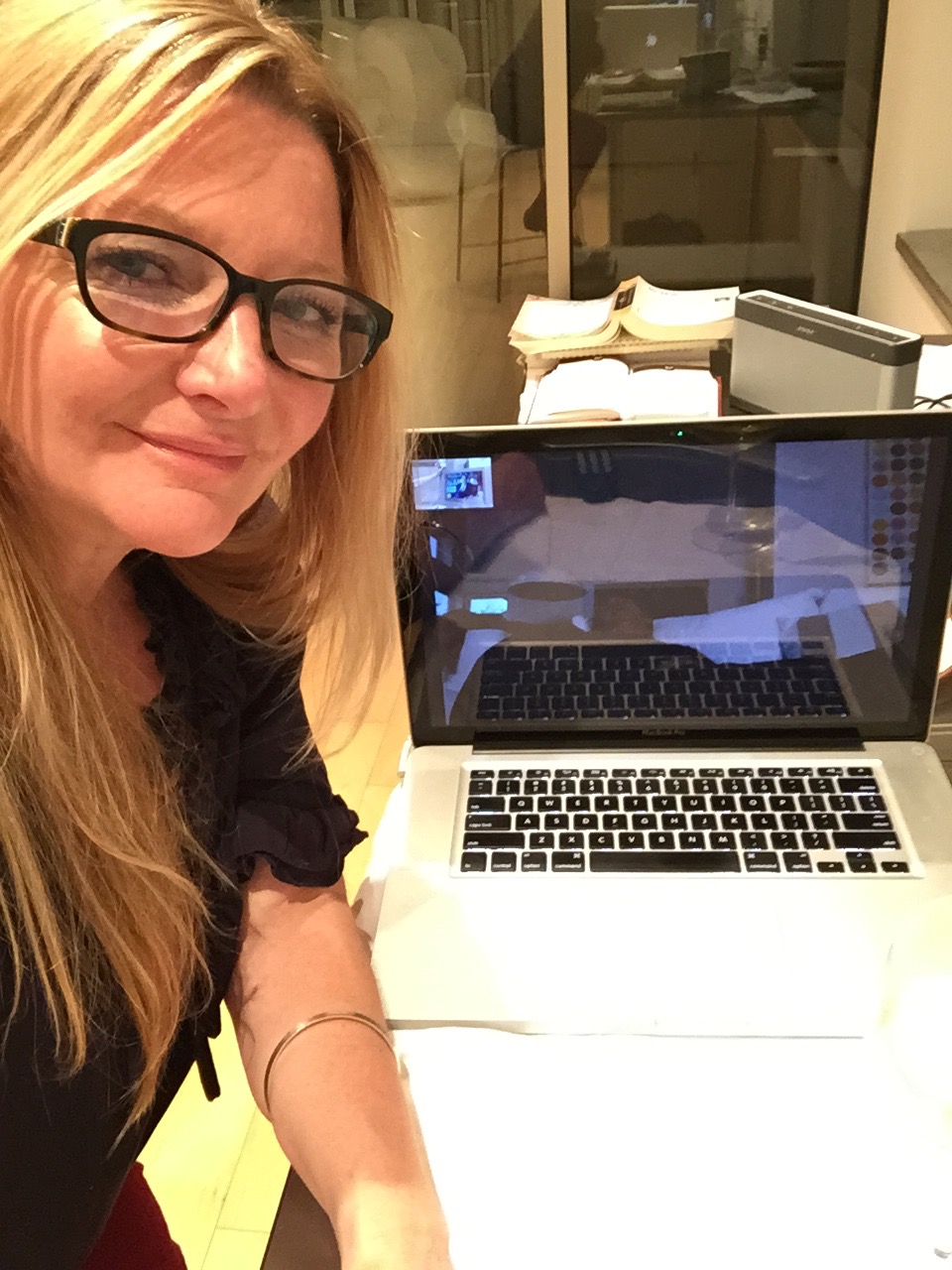 Jax Harrison wearing glasses beside an open laptop