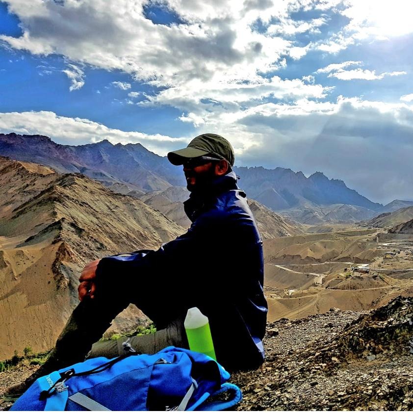 Jaydeep Barman seated outdoors against a mountain landscape