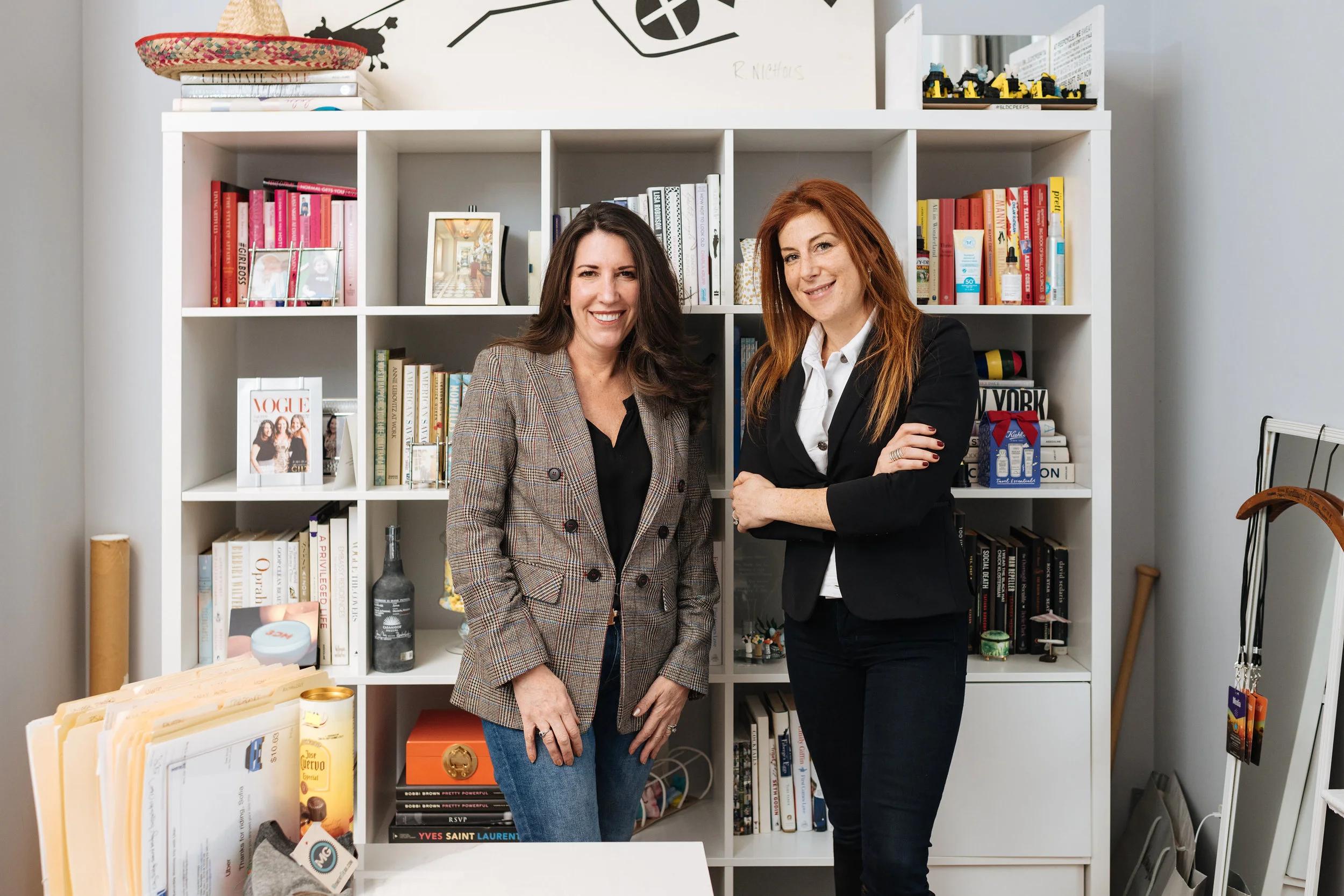 Jayne Sandman and Barbara Martin standing together in front of bookshelves at their office