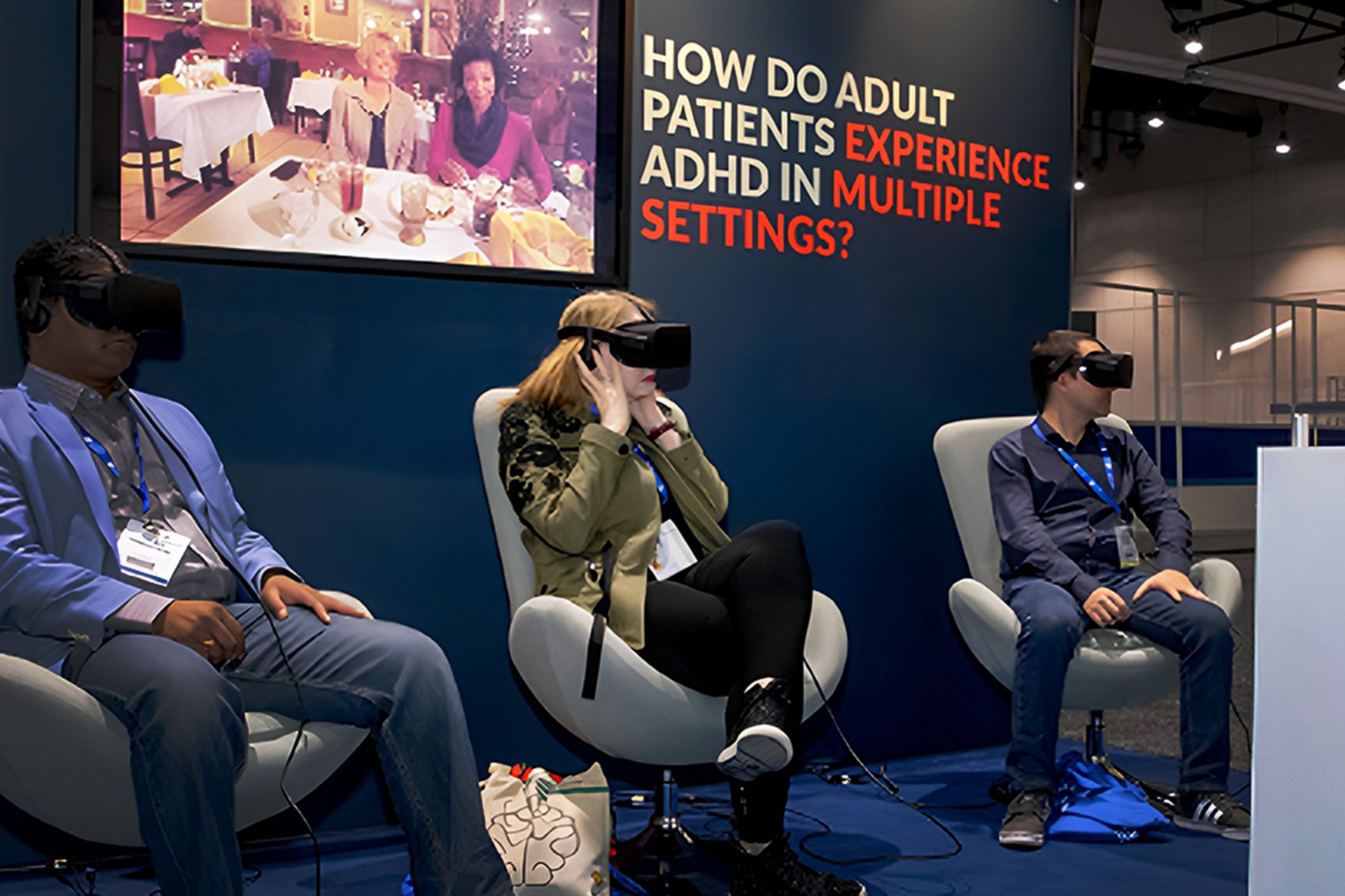 Three conference attendees wearing virtual-reality headsets at an adult ADHD education installation