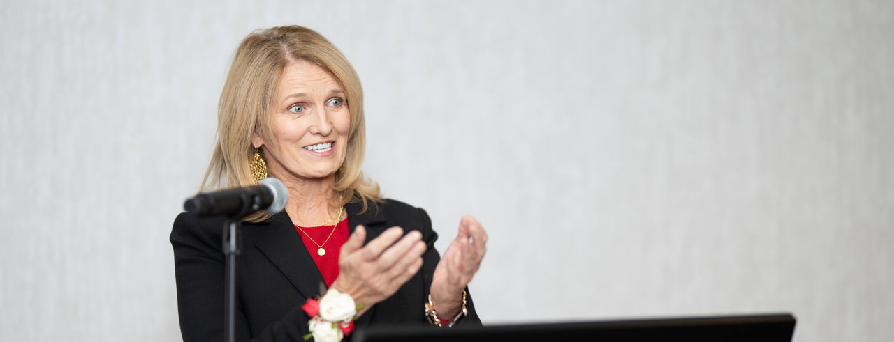 Jean Savage speaking at a podium during her University of Cincinnati visit
