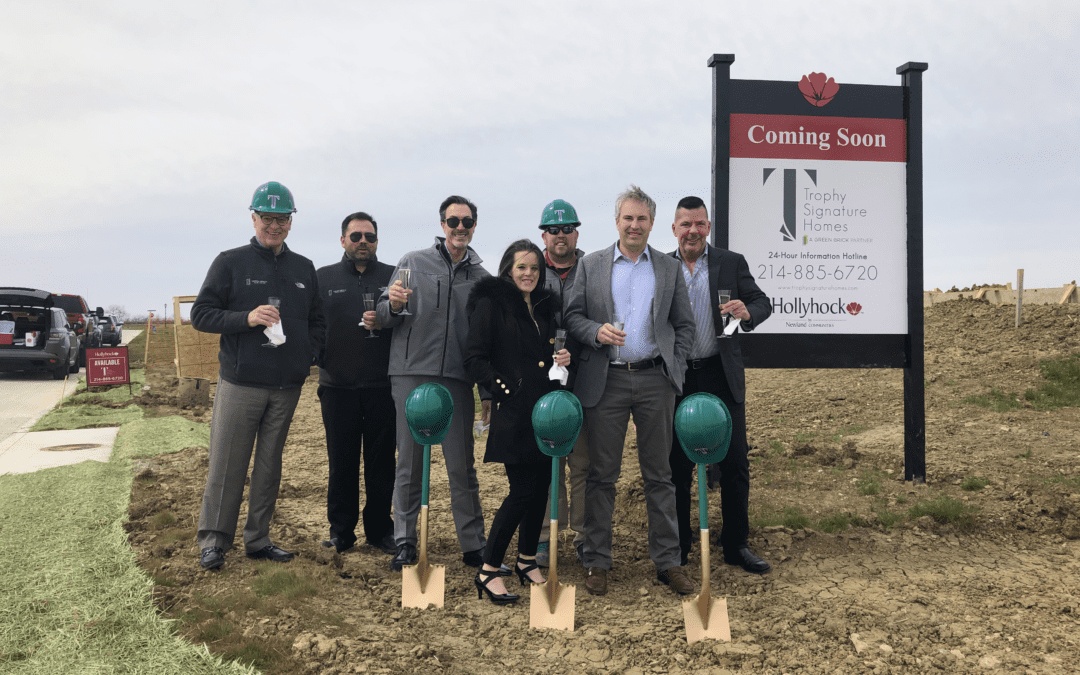 Group with green hard hats and ceremonial shovels at Trophy Signature Homes’ Hollyhock model-home groundbreaking