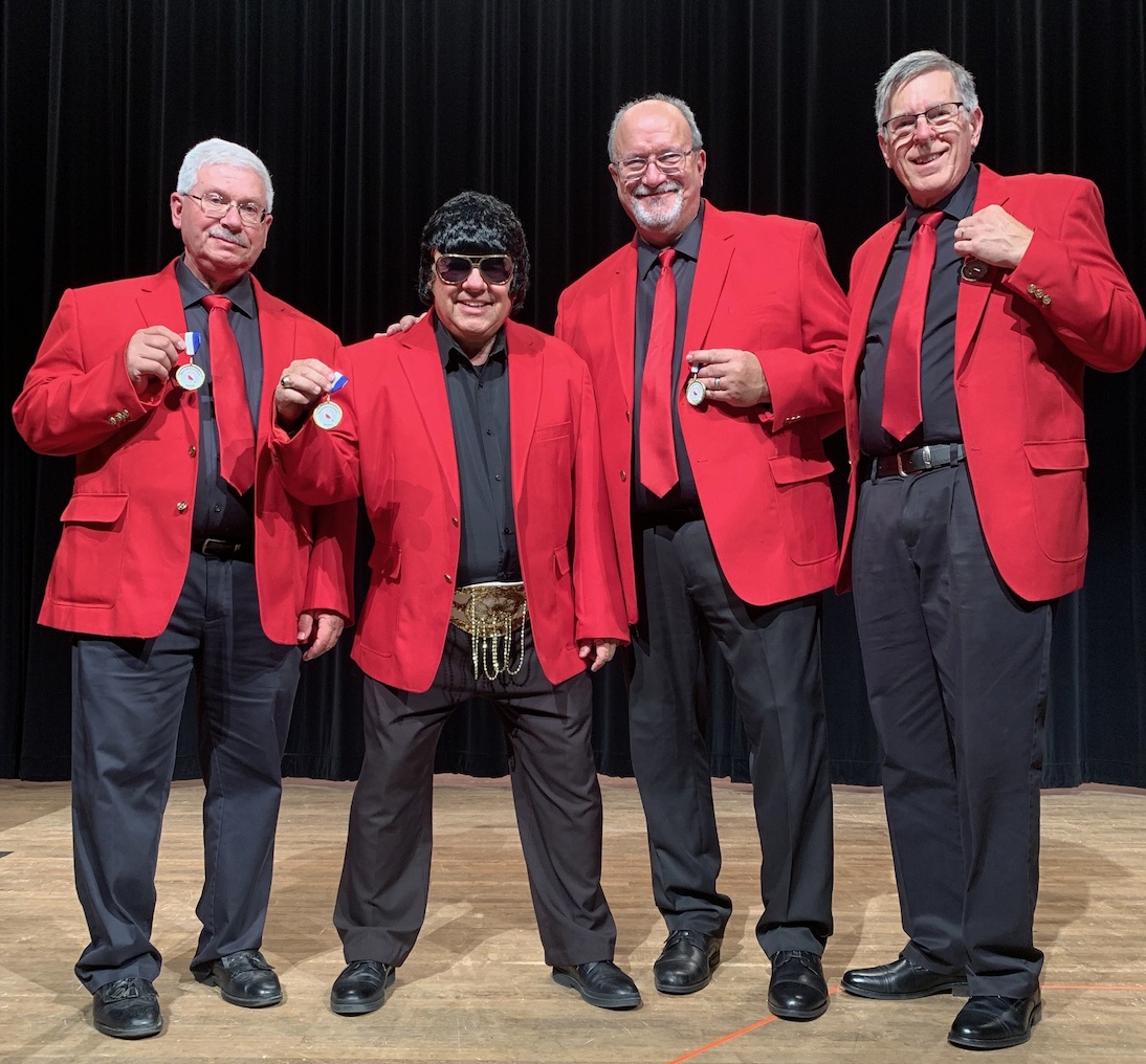 Coalition Quartet in red jackets with medals after its 2019 district senior competition win; Jeff Albert is third from the left.