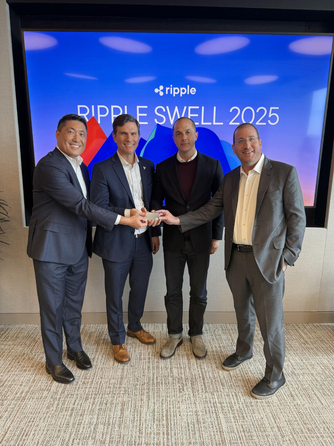 Jeff Berkson at right with fellow participants in front of a Ripple Swell 2025 display