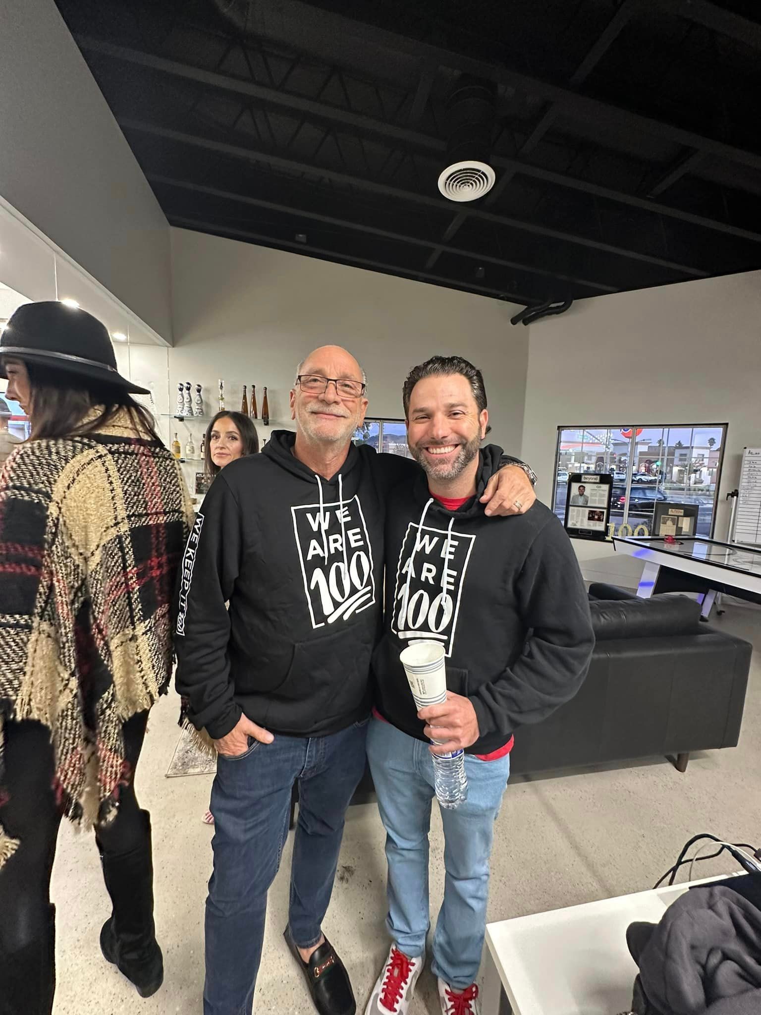 Rick Brodsly and Jeff Brodsly together at a 100GROUP gathering, wearing matching company hoodies
