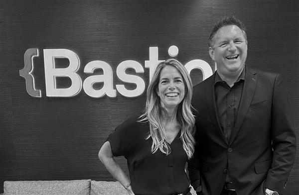 Jody Sowa and Jeff Browe smiling in front of a Bastion sign