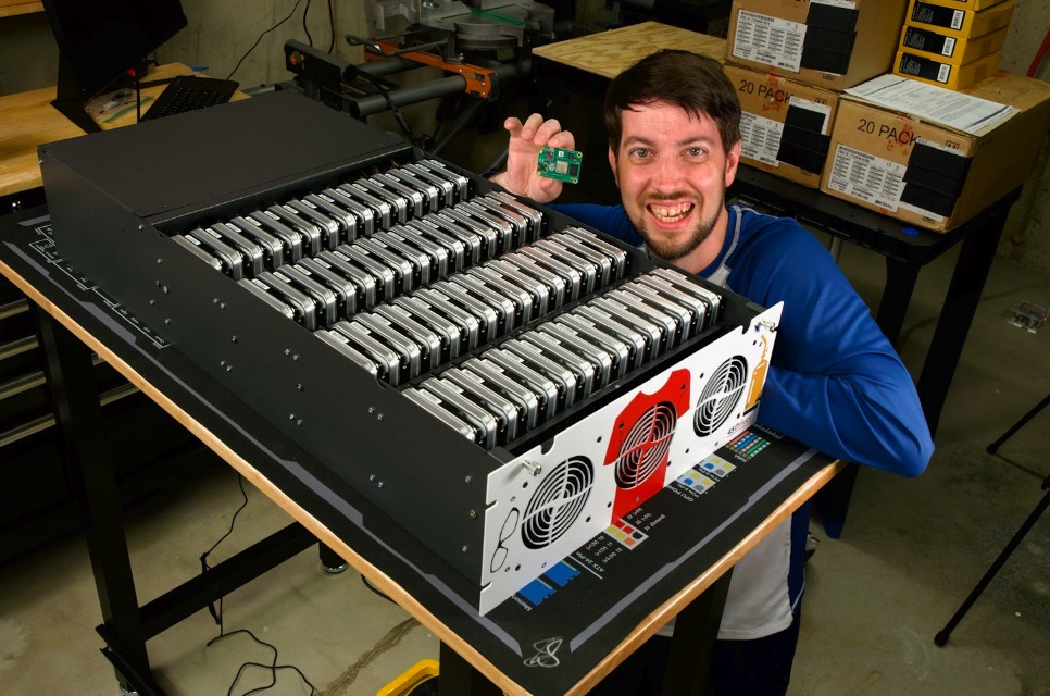 Jeff Geerling beside a large array of drives for his petabyte Raspberry Pi experiment