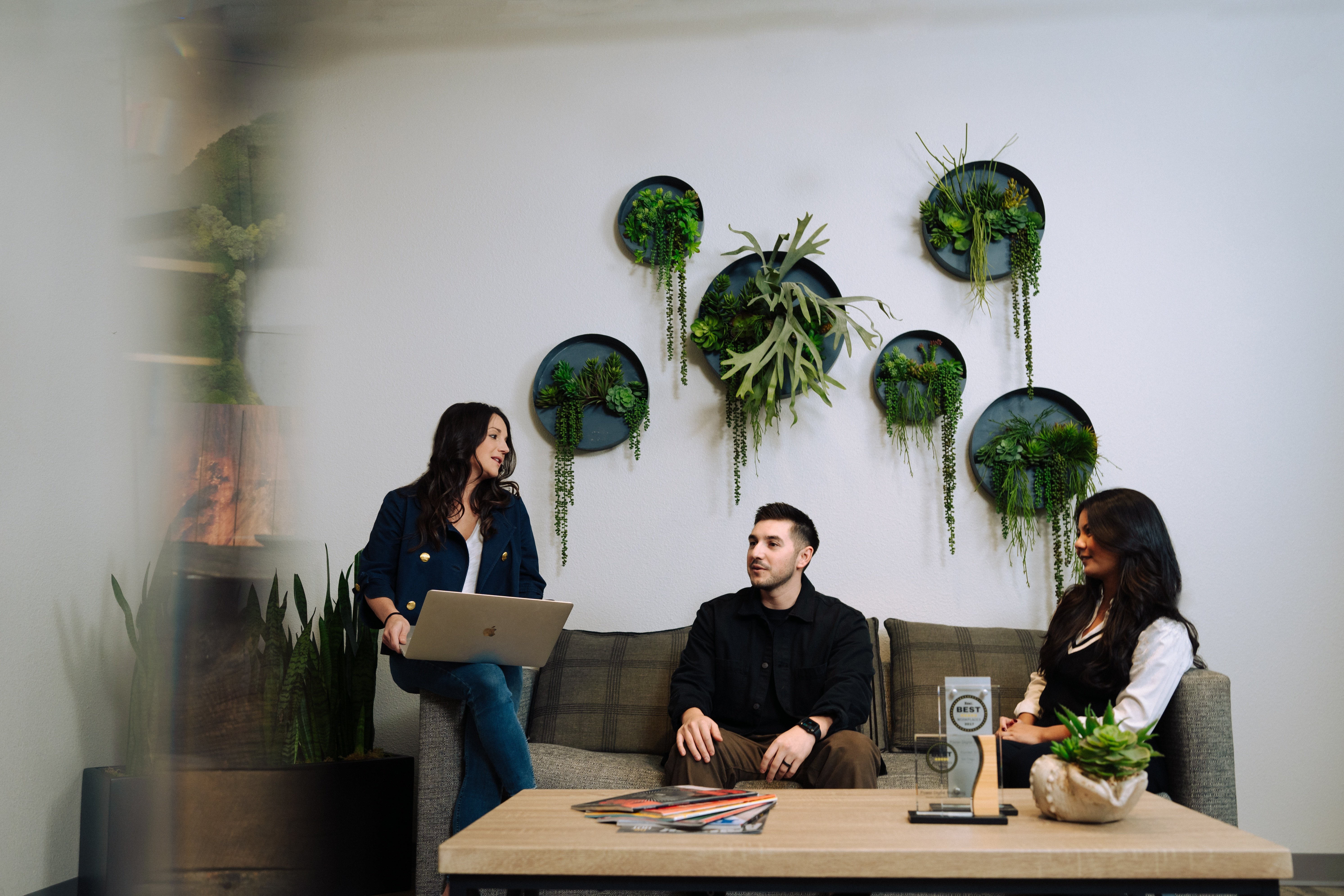 Three Power Digital team members talking in an office seating area