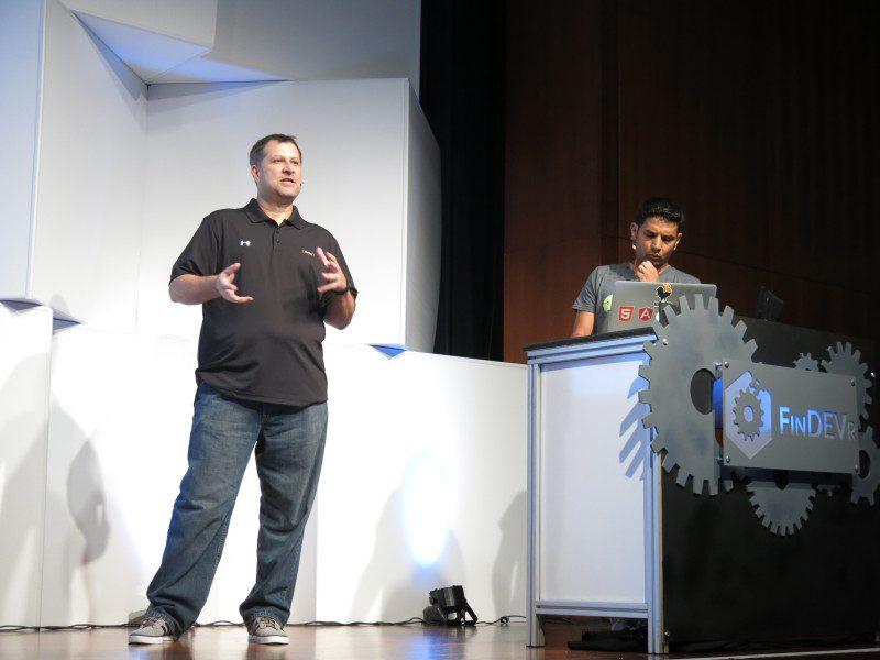 Jeff Thorness presenting on the FinDEVr stage beside a colleague at a lectern in 2015