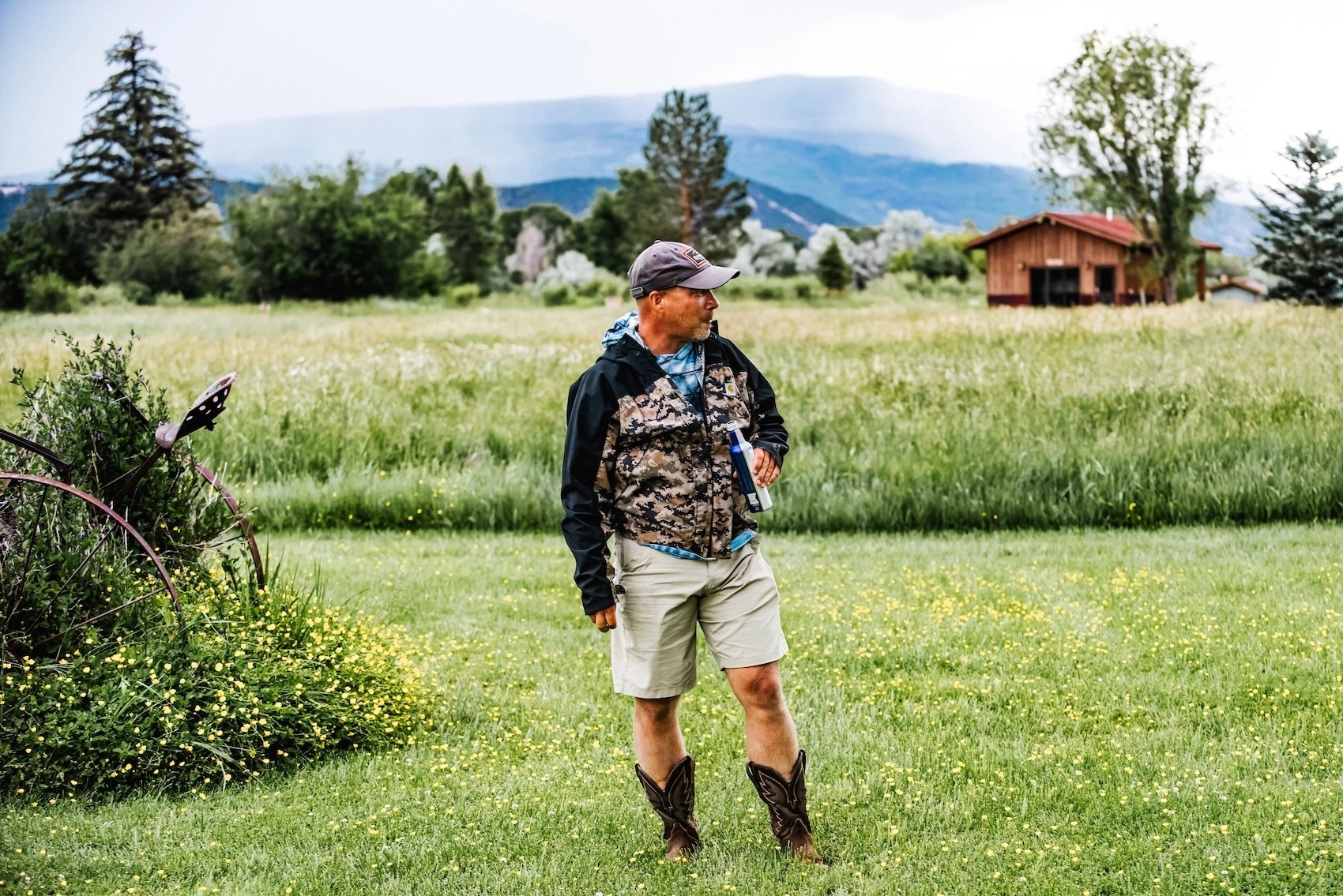 Jeff Tolle stands in a grassy field wearing a cap, shorts and boots