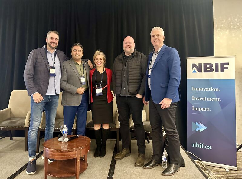 Five InnovateNB participants standing beside an NBIF banner, with Jeff White at the right