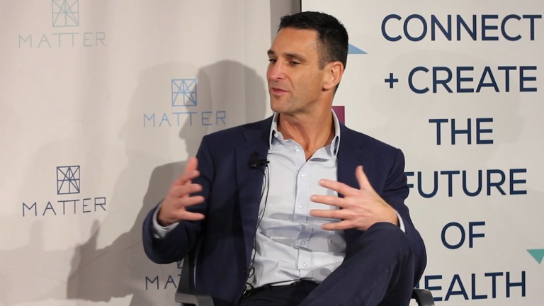 Jeff Aronin seated on stage and speaking with his hands at a MATTER event