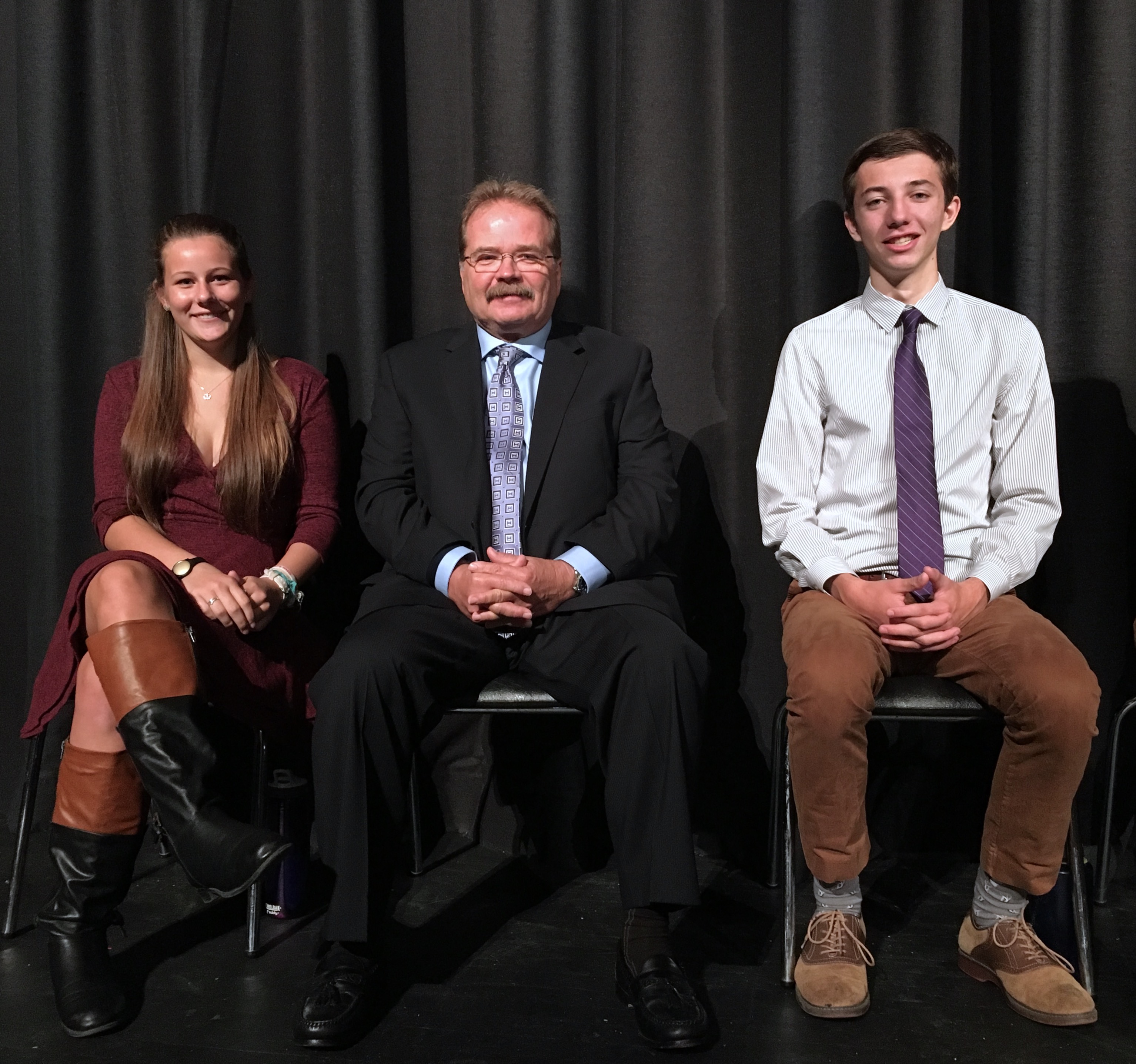 Jeffrey Barnhart seated between two Hopewell Valley high school seniors in 2016