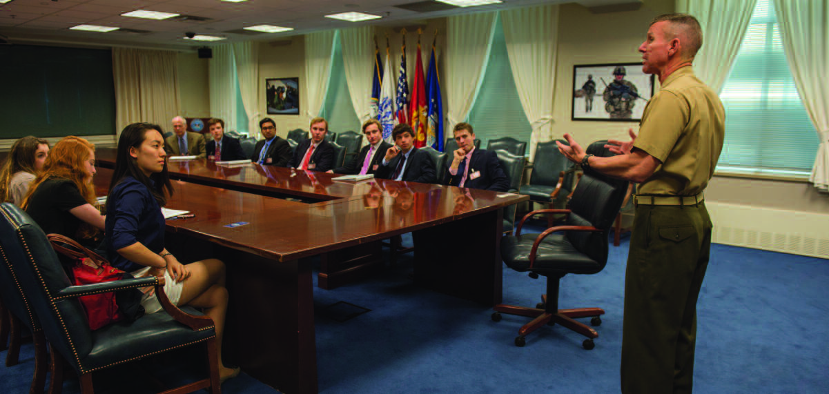St. George’s Rogers Scholars listen to a uniformed military speaker around a Pentagon conference table