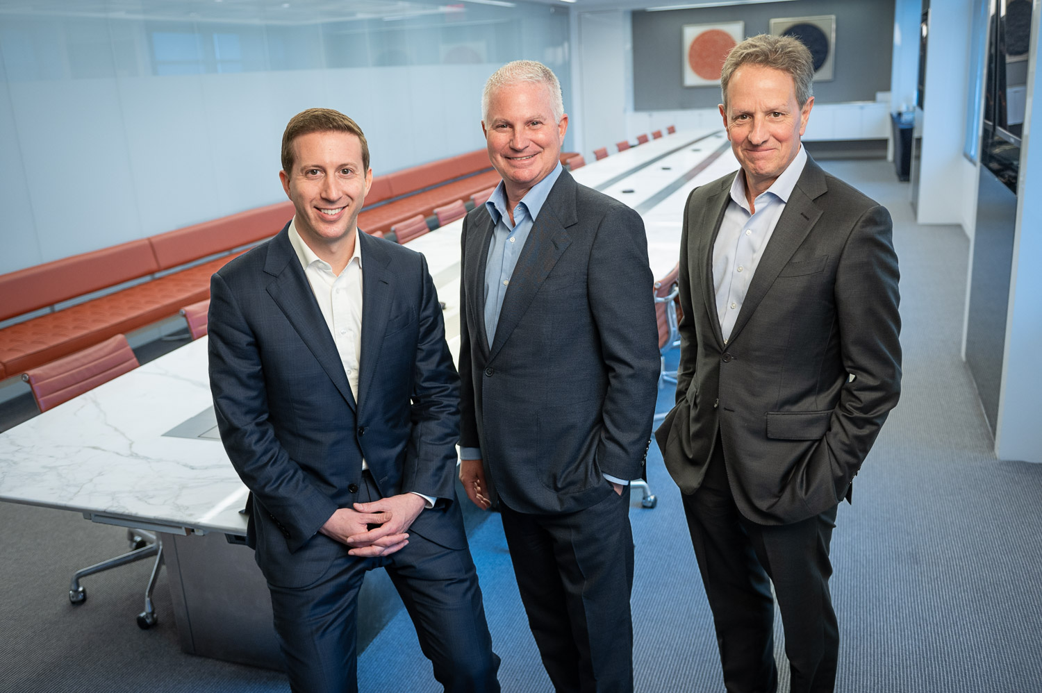 Jeffrey Perlman, Chip Kaye, and Timothy Geithner standing in a conference room