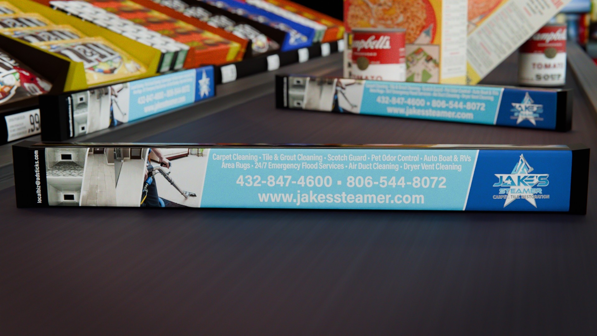 STARSTIX checkout dividers carrying a blue advertisement for Jake’s carpet cleaning business, positioned beside supermarket groceries