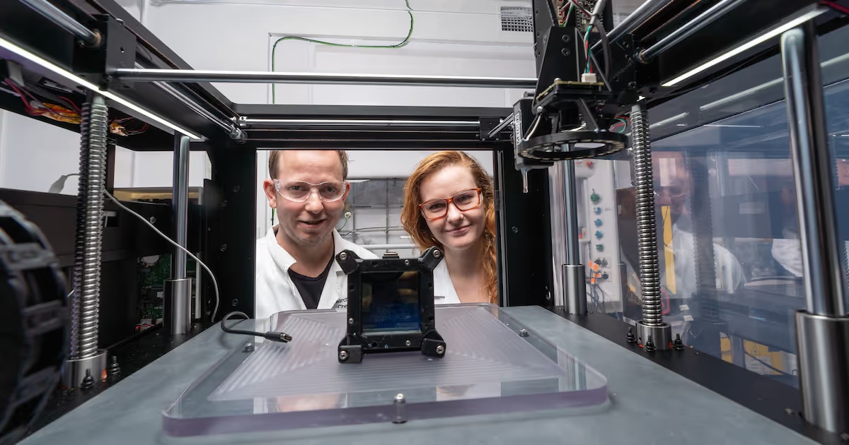 Luke Connal and Jekaterina Viktorova looking into an early Syenta printer in the ANU laboratory
