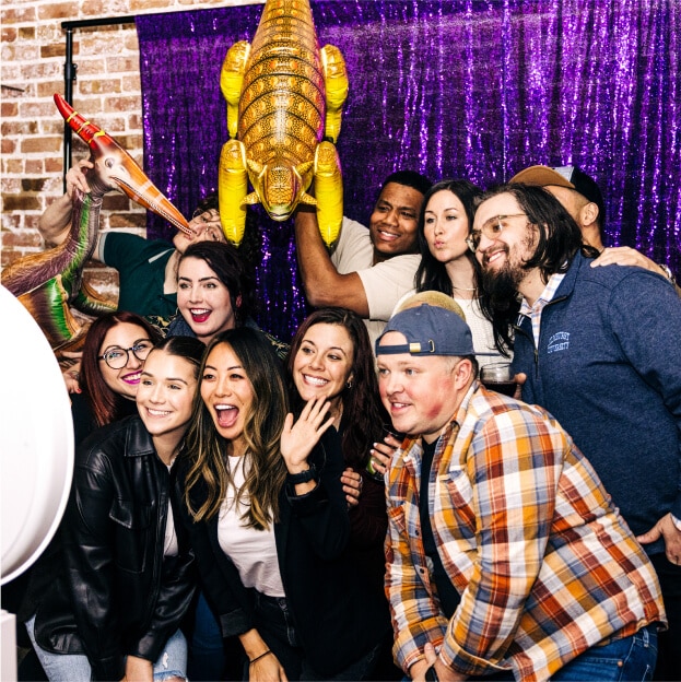 Jellyvision colleagues posing at a celebration with inflatable animal props