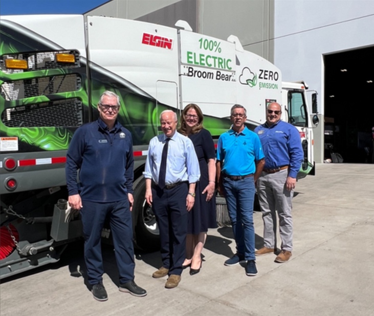 Jennifer Sherman with four colleagues beside an Elgin electric Broom Bear street sweeper at Federal Signal’s Denver facility opening