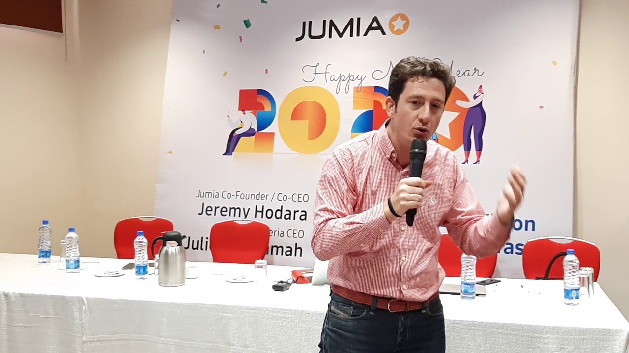 Jeremy Hodara speaking beside a Jumia Happy New Year 2020 event banner