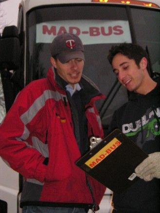 Jeremy Schwach, right, holding a Mad-Bus clipboard beside the original bus