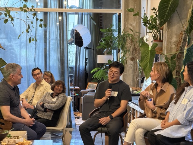 Jerry Li holding a microphone at a small roundtable in Gradual’s San Francisco office