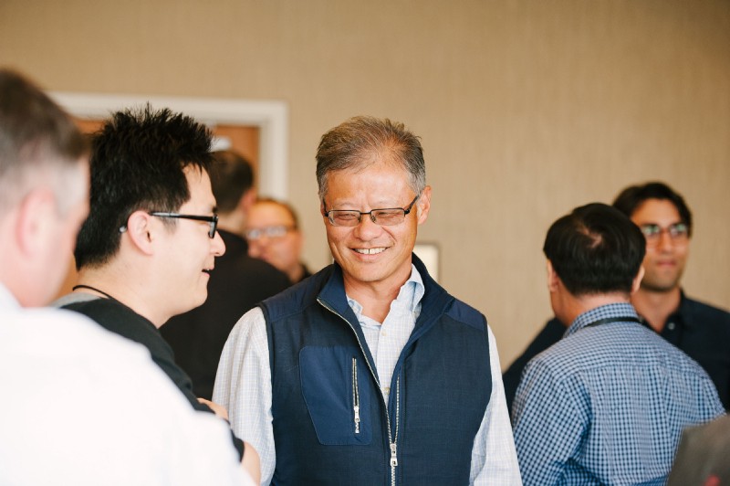 Jerry Yang smiling while talking with attendees at a Village Global gathering