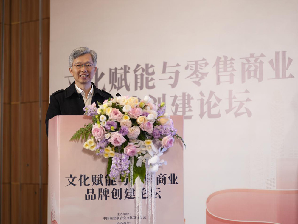 Jerry Zhang speaking behind a flower-covered lectern at the 2025 China Retailers Convention