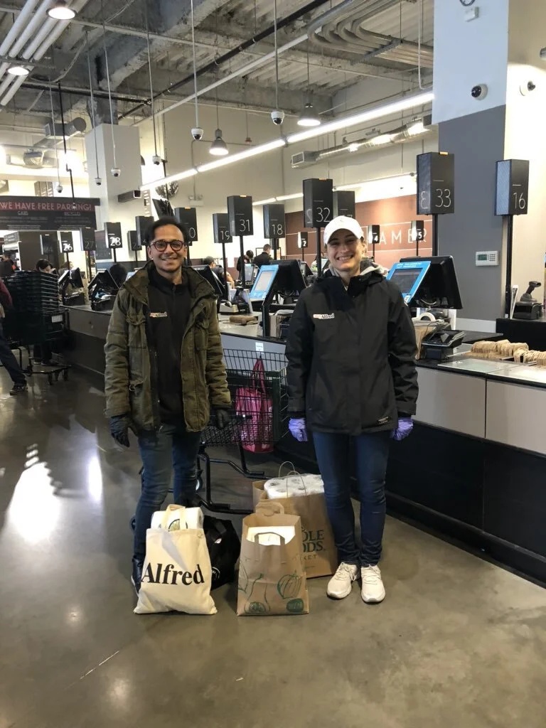Jessica Beck and an Alfred colleague with shopping bags at a grocery checkout
