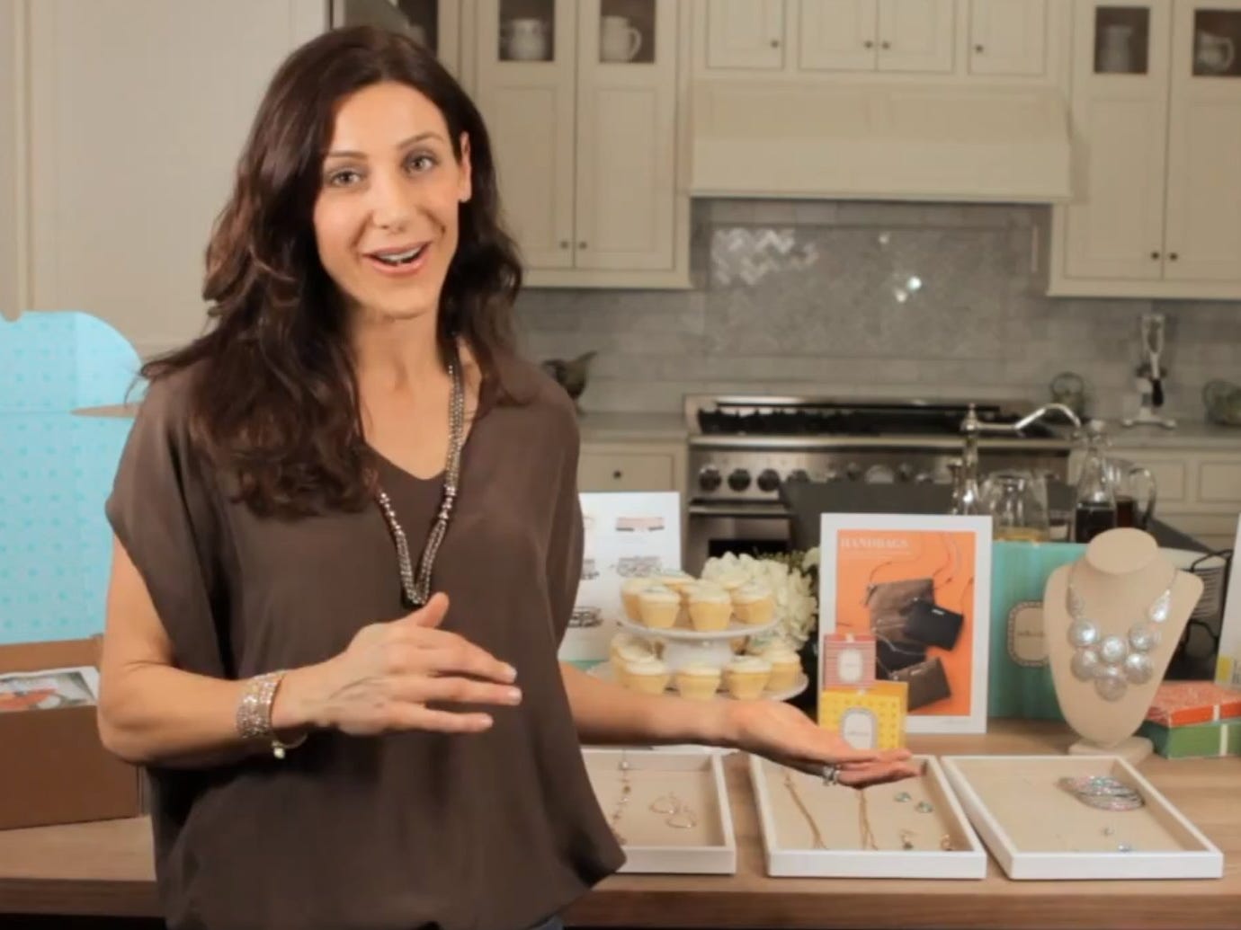 Jessica Herrin demonstrating Stella & Dot jewelry arranged on a kitchen counter