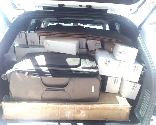 The open back of a car packed with boxes, luggage and early Amara sales materials