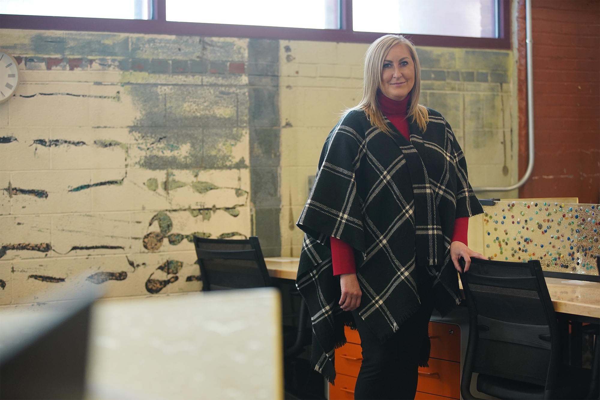 Jessica Sublett standing beside worktables in Bounce Innovation Hub’s industrial workspace