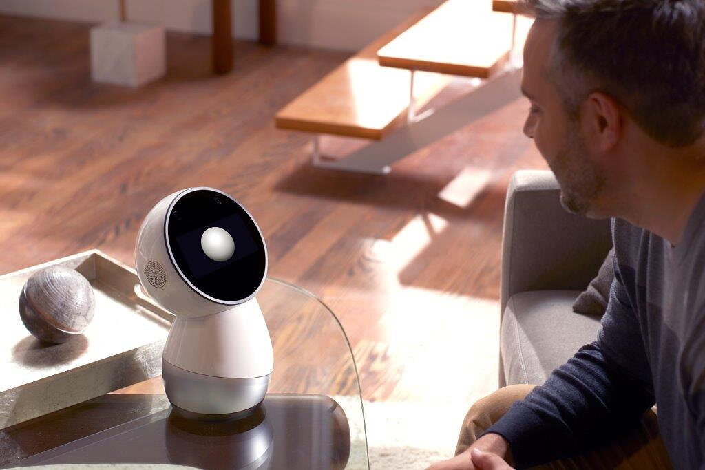 Jibo on a living-room table facing a seated person