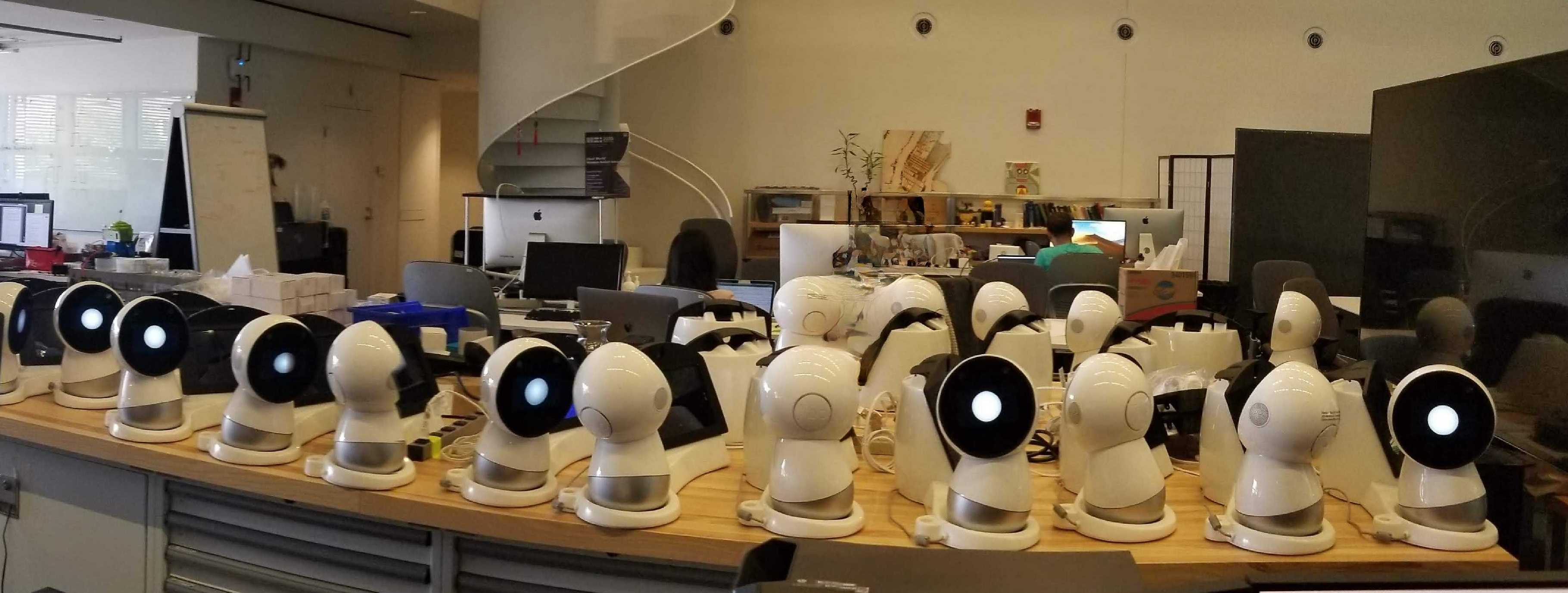 A collection of Jibo robots arranged on tables for research