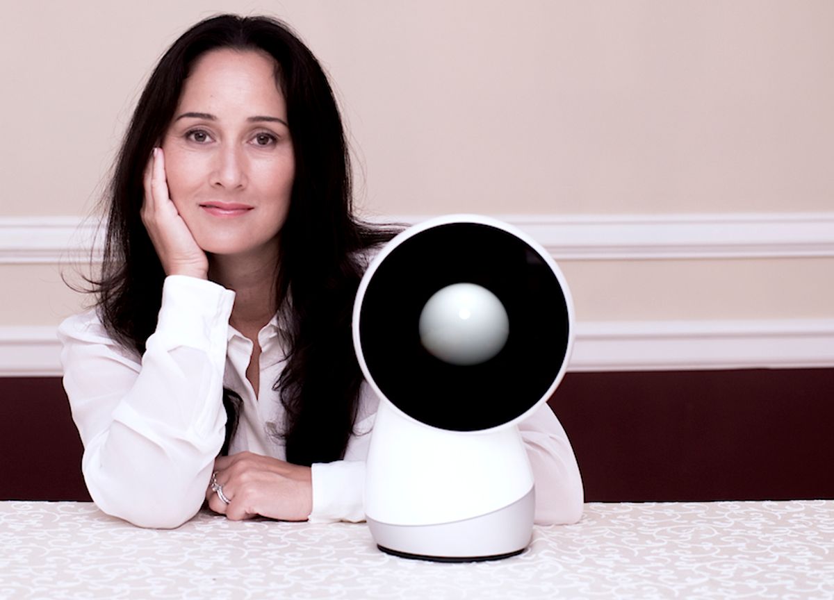 Cynthia Breazeal seated beside an early Jibo robot