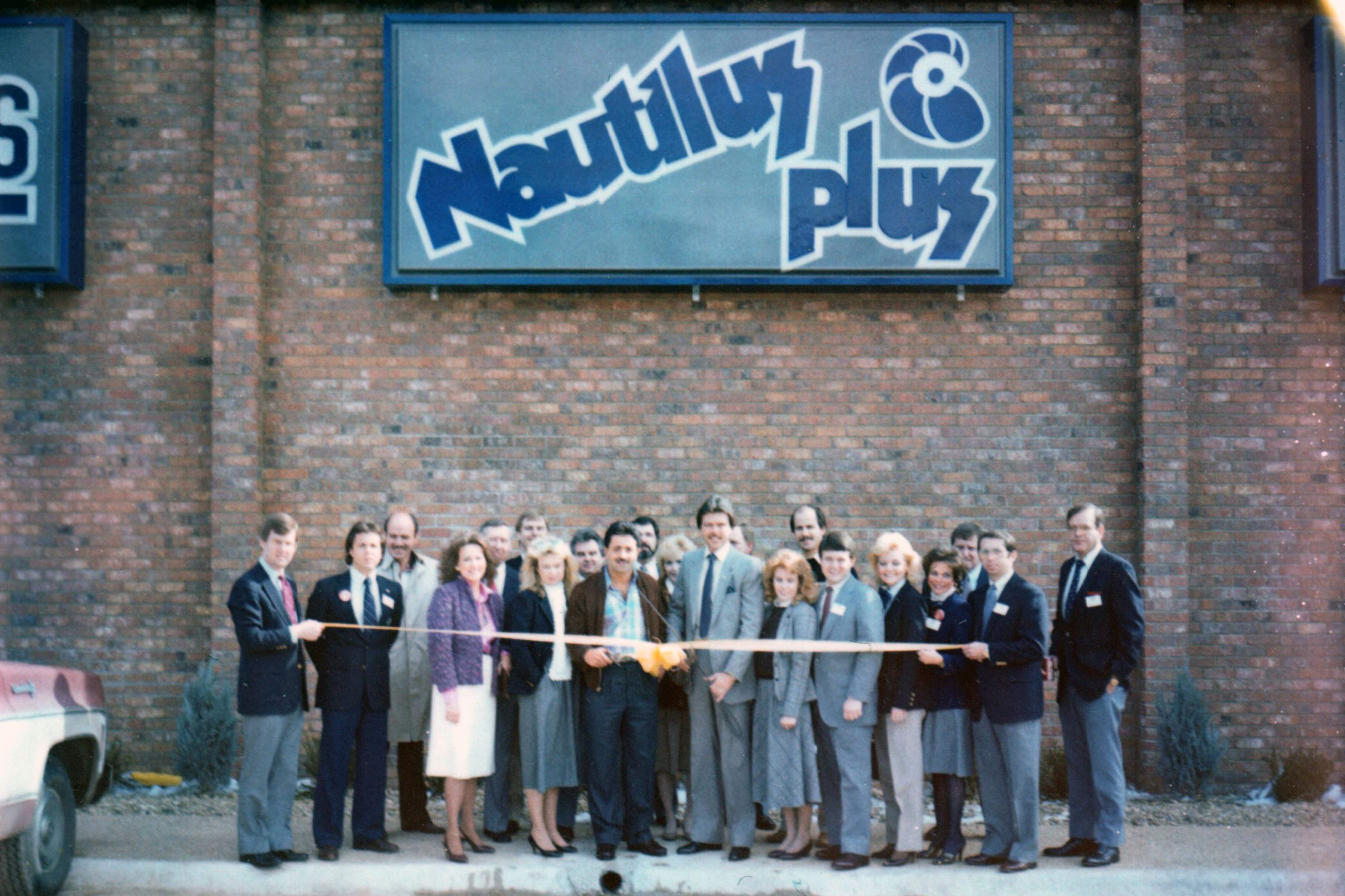 Jim Bottin and a group of colleagues gathered outside a Nautilus Plus location for a ribbon cutting