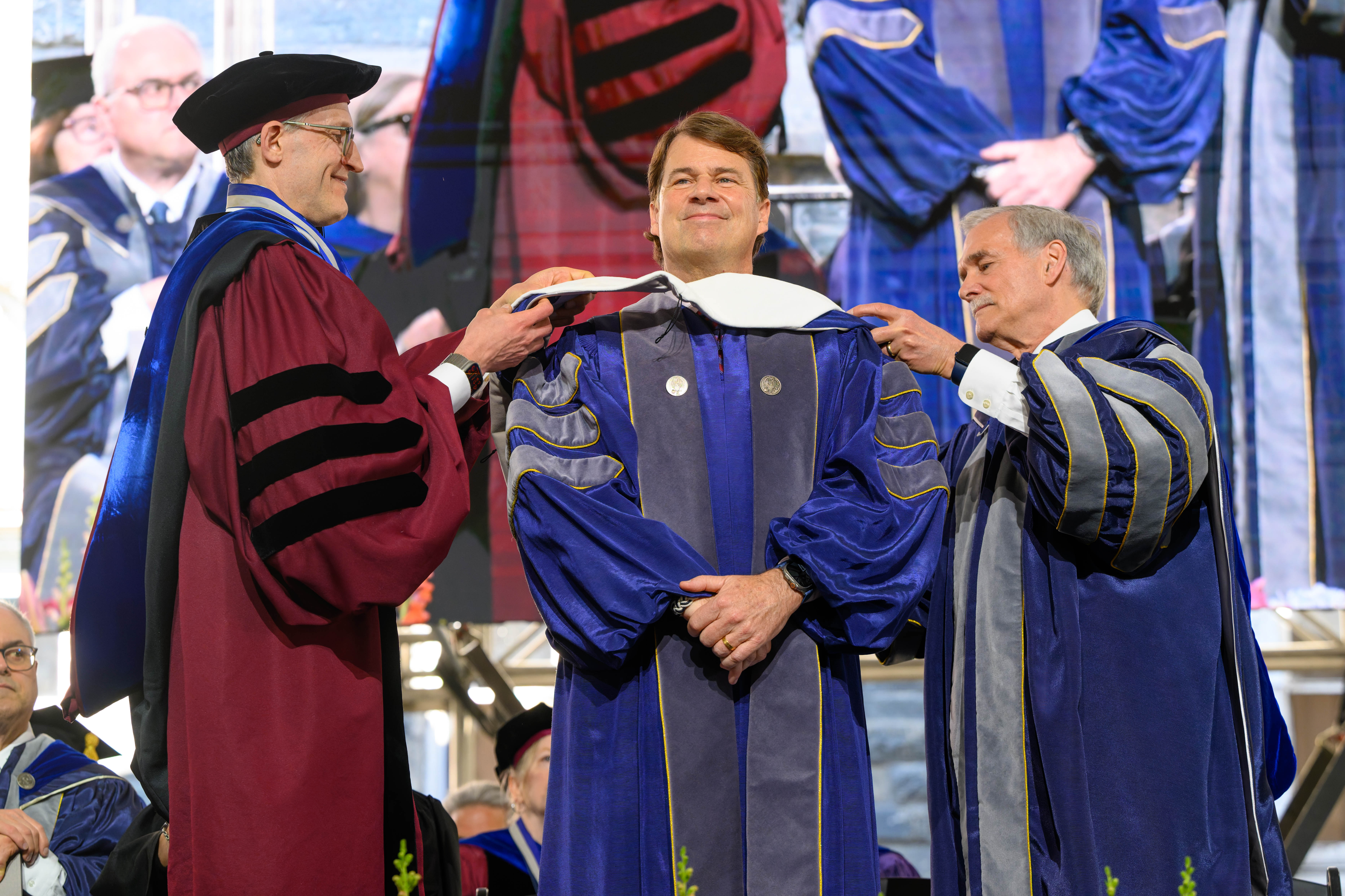 Jim Farley smiling as Georgetown leaders place an honorary degree hood on him in May 2026