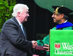Jim O’Donnell, at left, shaking hands with a graduate at Washington University