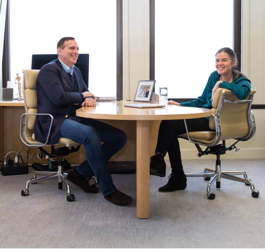 Jim Tananbaum smiling during a conversation across a round office table