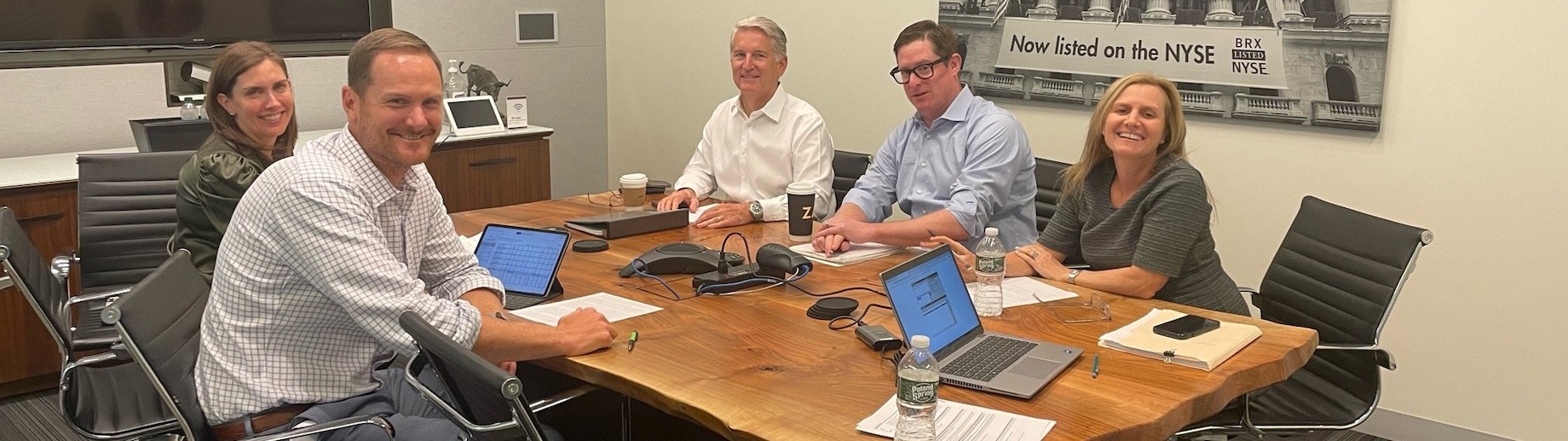 Brixmor executives gathered around a table for an earnings call, with Jim Taylor in the center
